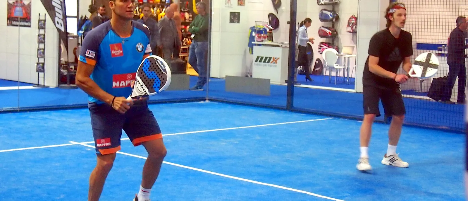 Twee spelers in een rally op een blauwe padelbaan