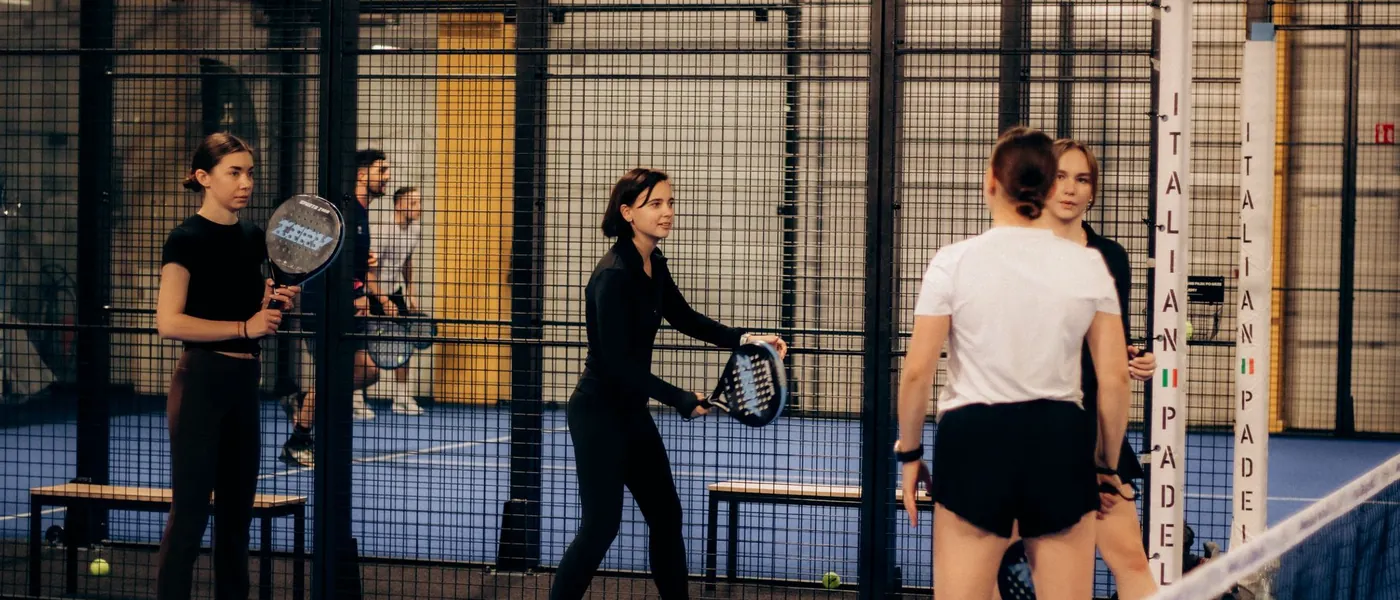 Vier spelers maken zich klaar voor een dubbelpartij op een binnenbaan